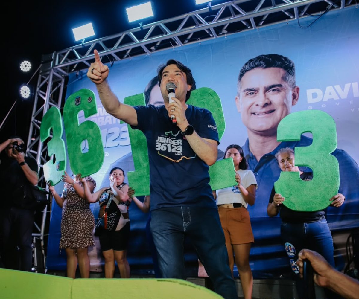 Jender Lobato discursa durante caminhada de encerramento da campanha eleitoral em Parintins, ao lado de apoiadores e do número de campanha.