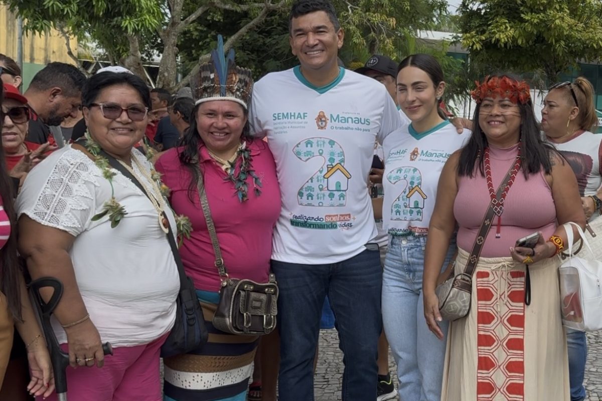 Secretário Jesus Alves ao lado de mulheres durante evento em Manaus ao falar sobre a maioria feminina na busca por moradia no cadastro habitacional.