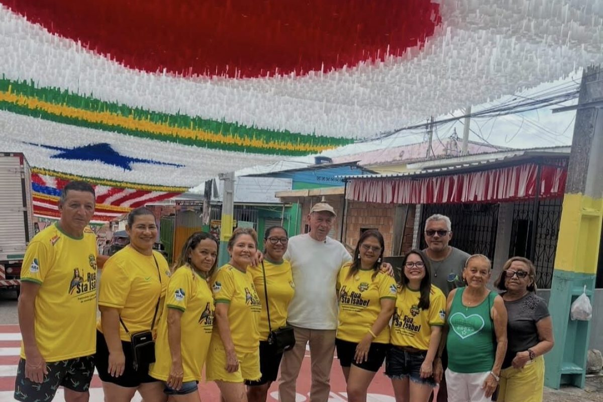 Grupo de moradores posa em rua decorada para a Copa do Mundo durante visita da campanha Rua da Copa da FM do Povo em Manaus.